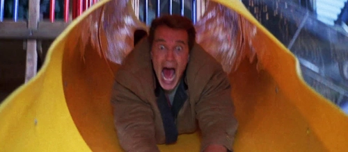 Arnold Schwarzenegger goes head first down a slide in 'Jingle All the Way' (1996).